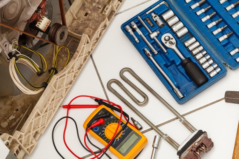 Engineer repairing a washing machine in Coulsdon